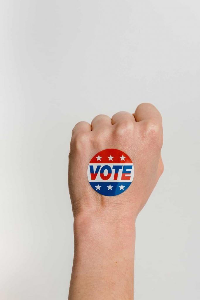 hand with a vote sticker on it